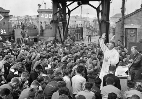 June 6, 1944, Catholic chaplain conducts services on a pier for the first D-Day assault troops in Weymouth, England