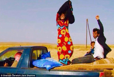 Syrian woman tears off her shapeless islamic black robe as she enters Kurdish-controlled territory