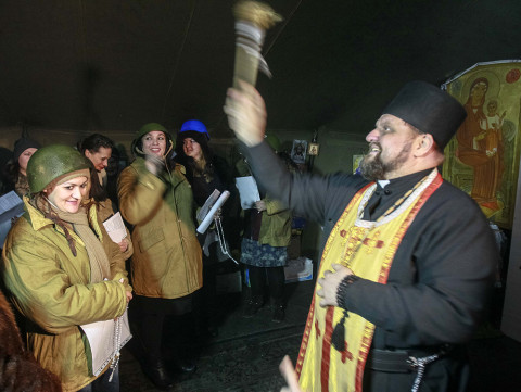 Ukrajinský katolický mejdan: A priest blesses anti-government activists, who formed a women's self-defence unit, inside a makeshift tent chapel at Independence Square in Kiev February 10, 2014. Photo: REUTERS/Gleb Garanich