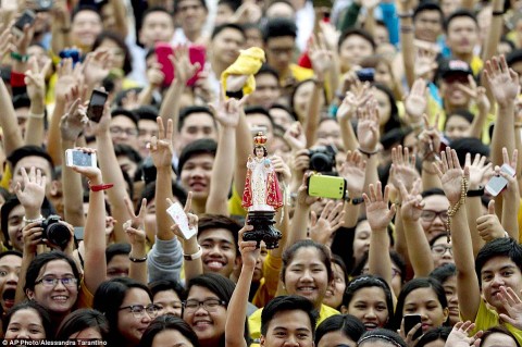 »Infant of Prague« is held up by a devotee as the crowd waits for Pope Francis to arrive at Santo Tomas University, 2015, photo: dailymail.co.uk